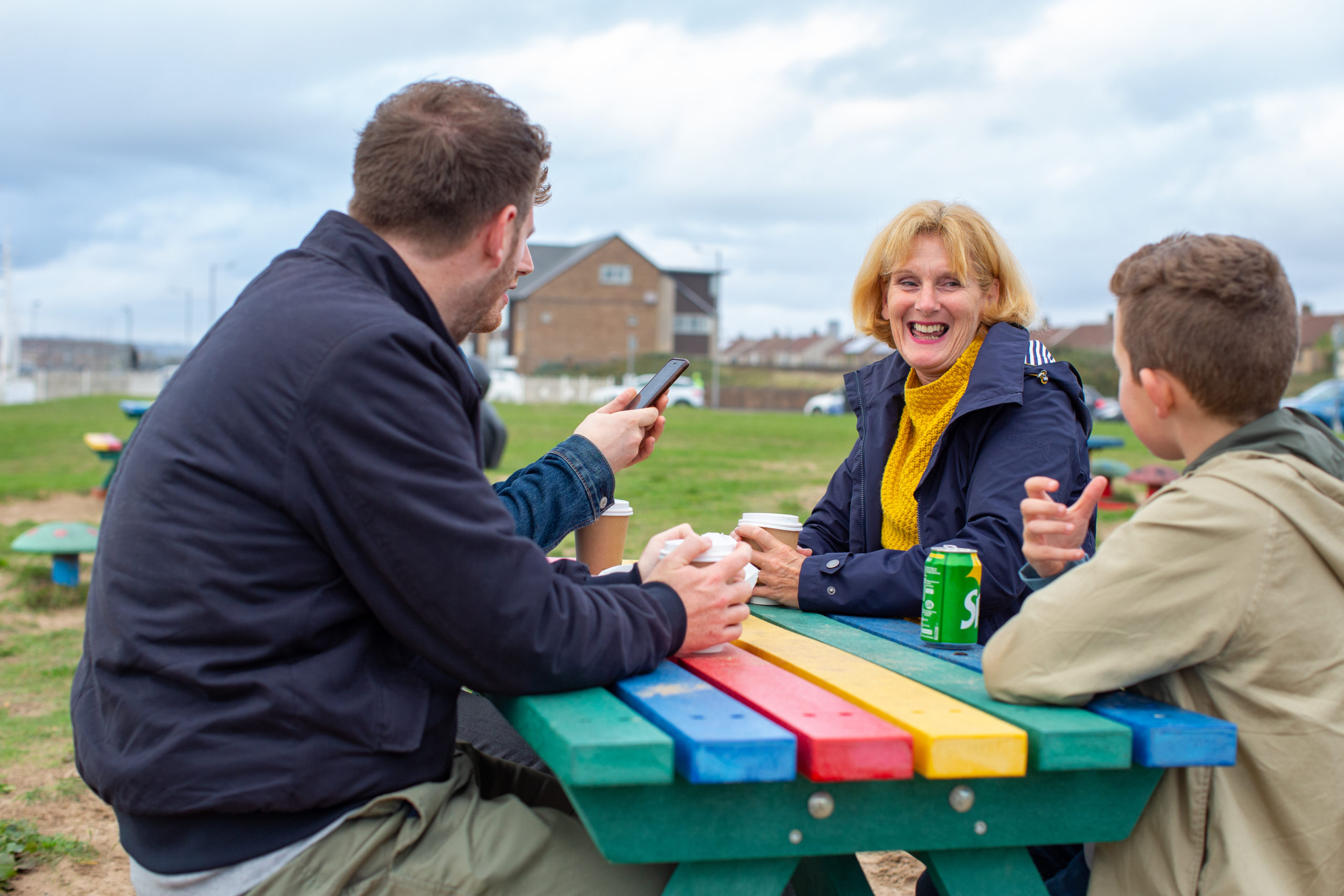 menyw yn chwerthin ac yn siarad i'w theulu