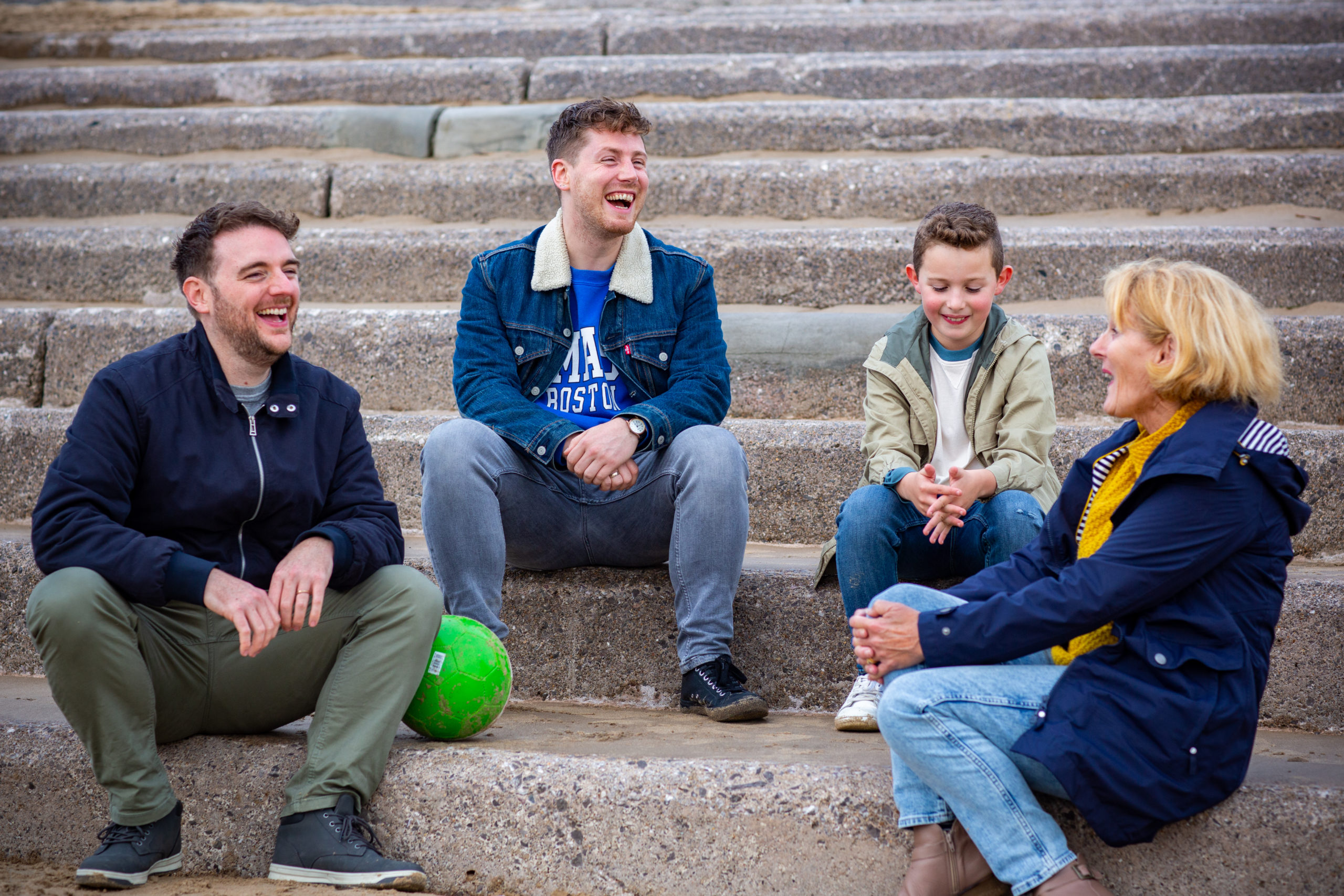 Family sitting down on steps in NPT beach