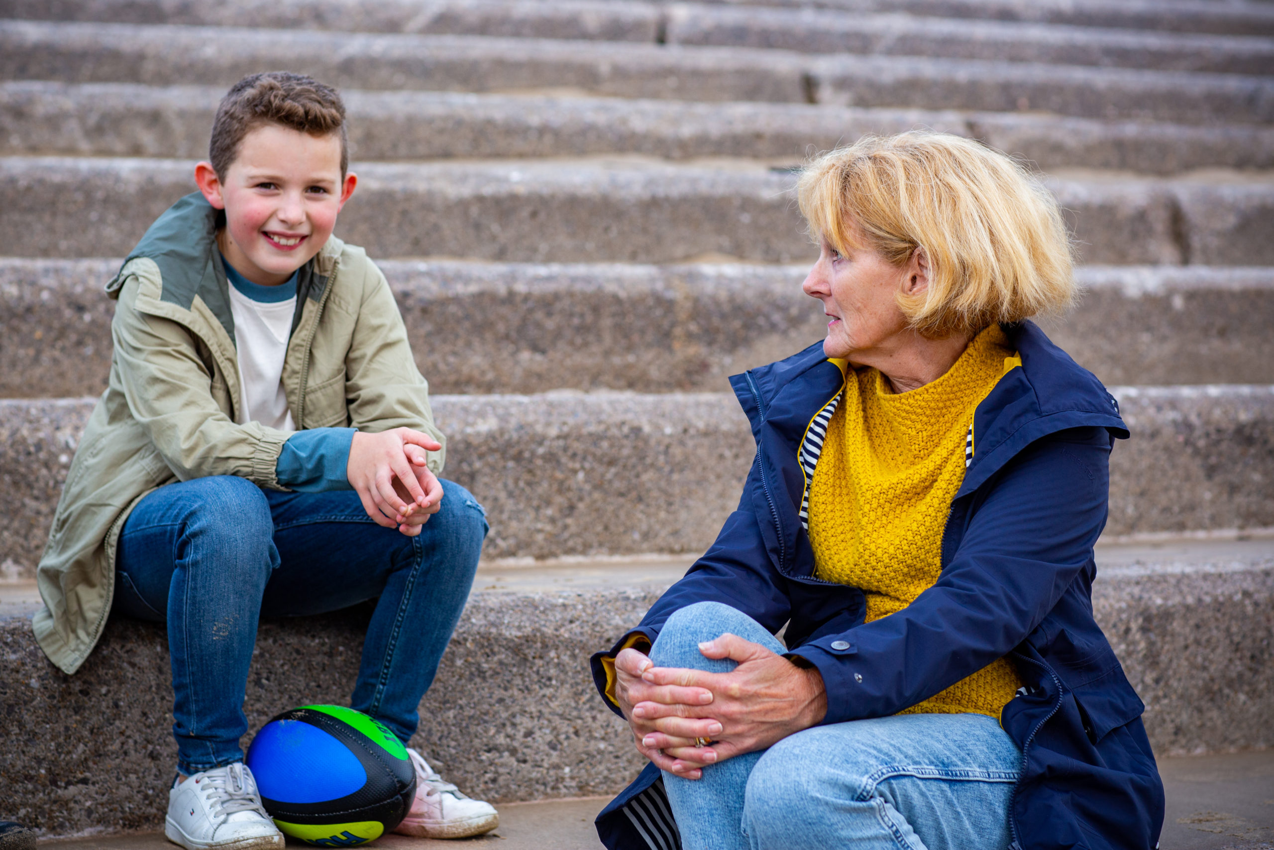 Woman and young boy sitting and chatting on some stairs