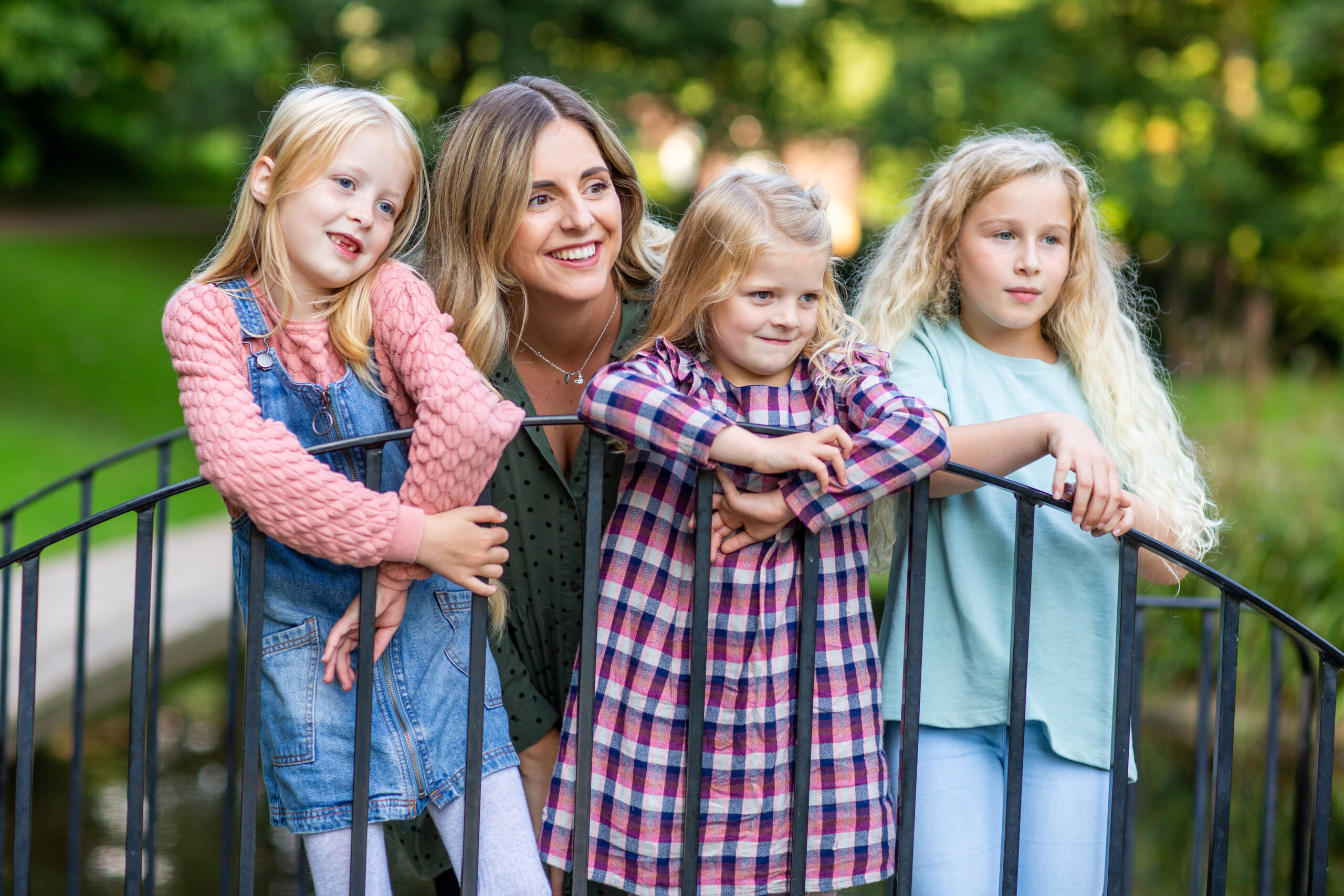 Single foster carer and three girls leaning on a gate